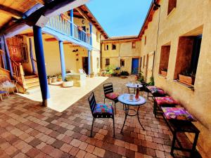 eine Terrasse mit Stühlen, einem Tisch und Stühlen in der Unterkunft Albergue Villares de Orbigo in Villares de Órbigo