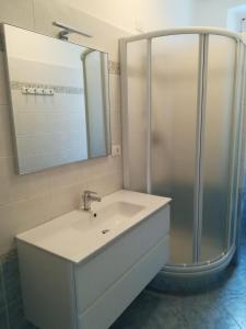 a bathroom with a sink and a shower with a mirror at La casa di Via Defferrari in Noli