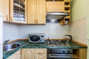 a kitchen with a stove and a microwave on a counter at Однокімнатні апартаменти на Майдані, дистанційне заселення 24х7 in Kyiv