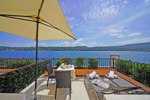 un patio con tavolo, sedie e ombrellone di Hotel Vigna a Salò