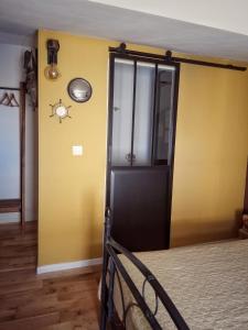 a bedroom with a black door and a yellow wall at La Dolce Vita - Chambre Amerigo Vespucci in Montpeyroux +20 photos