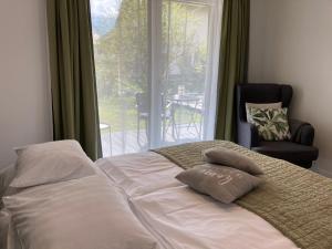 Bett mit zwei Kissen vor einem Fenster in der Unterkunft Kal's Studio Apartment Salzburg in Salzburg