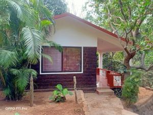 una pequeña casa con una ventana en el costado en Namaste Yoga Farm, en Gokarna