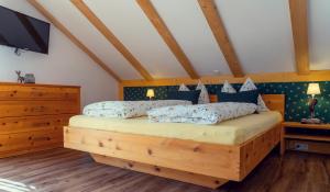 um quarto com uma cama de madeira e almofadas azuis em Ferienwohnung Leuner em Altaussee