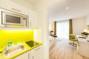 a kitchen with a sink and a microwave at acora Fürth Living the City- Apartments in Fürth