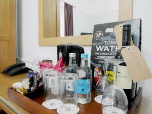 una mesa con botellas de vino y otros artículos. en Norton House Hotel - Mumbles en Swansea