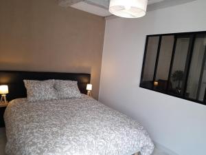 a bedroom with a bed and a window and two lamps at Le cosy d'Amboise in Amboise