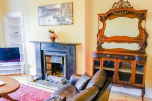 uma sala de estar com um sofá e uma lareira em Newly Furnished 2 Bedroom Apartment on Leith Walk em Edinburgo