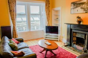 エディンバラにあるNewly Furnished 2 Bedroom Apartment on Leith Walkのリビングルーム(ソファ、暖炉付)