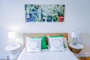 um quarto com uma cama com almofadas verdes e brancas em Newly Furnished 2 Bedroom Apartment on Leith Walk em Edinburgo