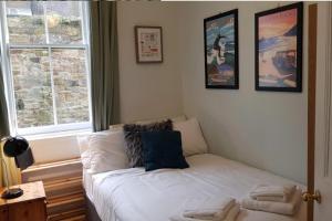 um sofá branco num quarto com cartazes na parede em Central 3 Bedroom next to Leafy Meadows em Edimburgo