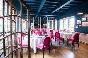 a dining room with tables and pink chairs at Domaine Saint Clair - Le Donjon in Étretat