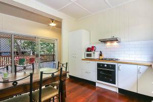 a kitchen with a table and a stove top oven at Walk to the Charming Character Home in Brisbane