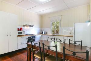 a kitchen with a wooden table and a refrigerator at Walk to the Charming Character Home in Brisbane