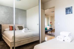 a bedroom with two beds and a mirror at Charming 1 Bedroom Apartment in Vibrant South Yarra in Melbourne