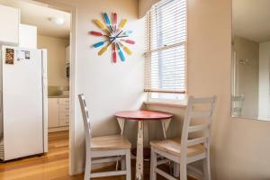 a kitchen with a table and two chairs and a clock at Charming 1 Bedroom Apartment in Vibrant South Yarra in Melbourne