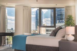 a bedroom with a bed with a view of a city at 1 Bed Studio Apartment Near Eagle Street in Brisbane