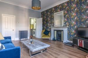 a living room with a blue couch and a fireplace at Bright 1 Bedroom Flat Minutes from the Beach and Trains in Brighton & Hove
