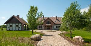 a house with a gravel driveway in front of it at Hotel SPA Dr Irena Eris Wzgórza Dylewskie - Siedliska in Wysoka Wieś