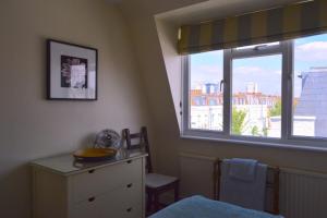 un dormitorio con una ventana y una mesa con un tazón. en Lovely Top Floor Flat in Leafy Fulham, en Londres