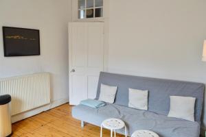 a living room with a blue couch and a table at Central and Inviting 2 Bedroom ApartmentPerfect for Festival in Edinburgh