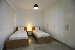 deux lits dans une petite pièce avec des armoires blanches dans l'établissement Villa Oniron, à Coral Bay 34 autres photos