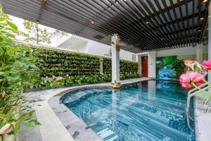 a swimming pool in a building with plants at An Phú Villa and Golf FLC Sầm Sơn in Sầm Sơn