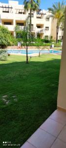 a tree in the middle of a field of grass at Bevs ground floor Roda Golf Apartment! in San Javier
