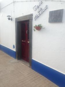 a red door on the side of a white building at Recanto na Planicie in Monsaraz