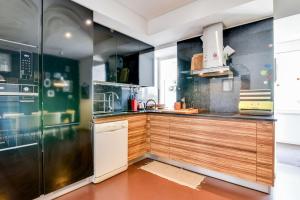 リスボンにあるCharming 2 bedroom apartment at Resteloのキッチン(木製キャビネット、ステンレス製の冷蔵庫付)