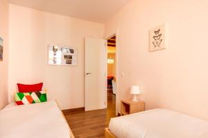 a small bedroom with two beds and a lamp at Modern 2 Bedroom Flat in Trendy Poble Sec in Barcelona