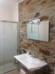 a bathroom with a sink and a stone wall at Recanto na Planicie in Monsaraz