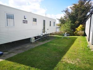 a white trailer is parked in a yard at The Abi Joseph @Combe Haven in Hastings