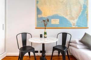 a table with two chairs and a map on the wall at Boutique Studio Apartment at Potts Point in Sydney