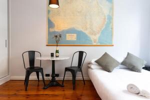 a room with a couch and a table with chairs at Boutique Studio Apartment at Potts Point in Sydney