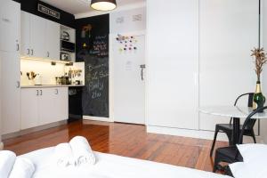a room with white cabinets and a table and a kitchen at Boutique Studio Apartment at Potts Point in Sydney