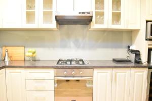 a kitchen with white cabinets and a stove at Bright 2 Bedroom Apartment In A Great Location in Perth