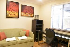 uma sala de estar com um sofá e um piano em Bright 2 Bedroom Apartment In A Great Location em Perth