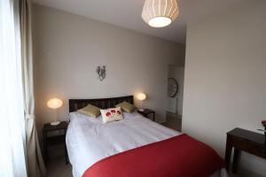 una camera con un letto rosso e bianco con due lampade di Stylish light-filled 1 Bedroom Flat In Hammersmith a Londra