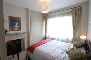 a bedroom with a bed and a television and a window at Stylish light-filled 1 Bedroom Flat In Hammersmith in London