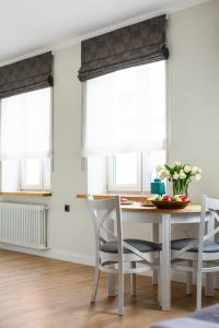 a dining room with a table and chairs and windows at Right Stay Studio in Gdańsk