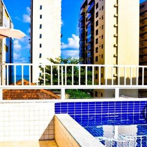 a balcony with a swimming pool and some tall buildings at Hotel Porto Segur0 in Recife