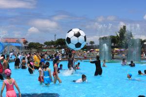 eine Gruppe von Menschen, die in einem Pool mit einem Fußballball spielen in der Unterkunft Dongshan River Resort Farm in Wujie