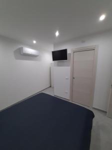 a white room with a black rug and a door at Maresole Cefalù in Cefalù