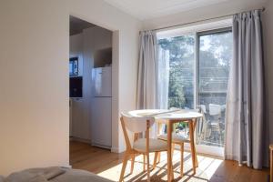 a kitchen with a table and two chairs and a window at Sun-Drenched 1 Bed Studio Apartment In Newtown in Sydney