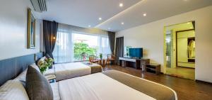 a hotel room with two beds and a television at An Phú Villa and Golf FLC Sầm Sơn in Sầm Sơn +36 photos