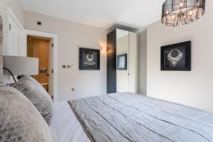 een slaapkamer met een groot bed en een kroonluchter bij Luxury Mayfair 2 Bedroom Apartment in Londen