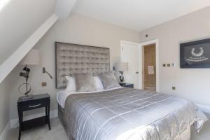 een witte slaapkamer met een groot bed en een trap bij Luxury Mayfair 2 Bedroom Apartment in Londen
