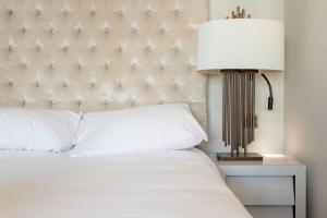 een slaapkamer met een wit bed en een lamp bij Luxury Mayfair 2 Bedroom Apartment in Londen