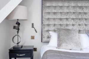 een slaapkamer met een bed en een bakstenen muur bij Luxury Mayfair 2 Bedroom Apartment in Londen